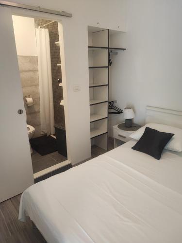 a bedroom with a white bed and a shower at Apartment MARI in Ostrvica