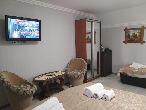 a hotel room with a bed and a tv on the wall at Villa Magnat in Berehove