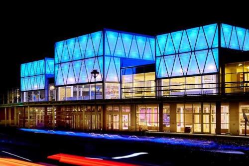 a large building with blue lights on it at night at 170 M2 stort hus tæt på centrum, MCH og Boxen in Herning