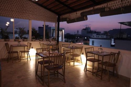 a restaurant with tables and chairs on a balcony at night at Jai Villa - A Boutique Hotel in Jaipur