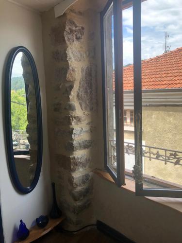 a room with two windows and a stone wall at Mademoiselle Canonge in Lamastre