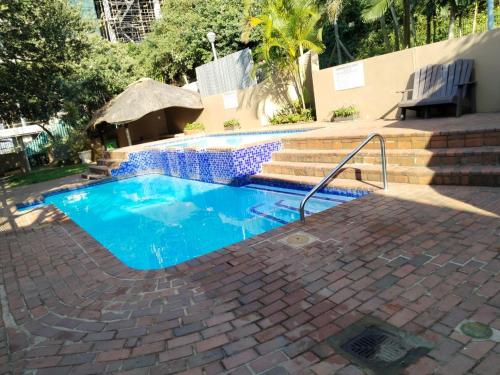 a small swimming pool with blue water in a yard at 21 Camarque in Umdloti