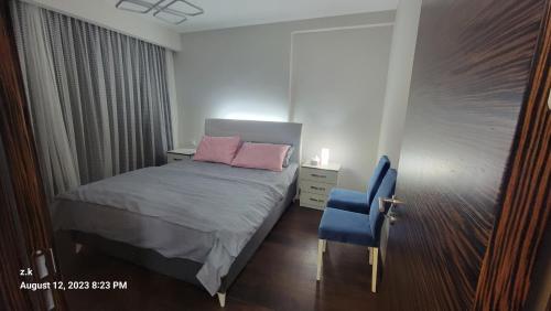 een kleine slaapkamer met een bed en een blauwe stoel bij istanbul7 in Istanbul