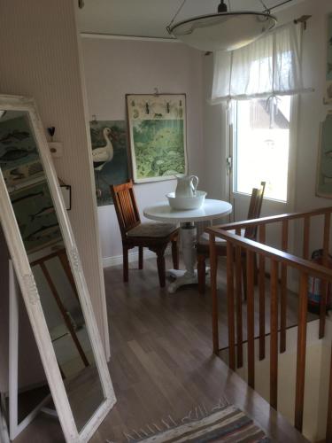 a dining room with a table and a mirror at Charmig Ölandsgård in Köpingsvik