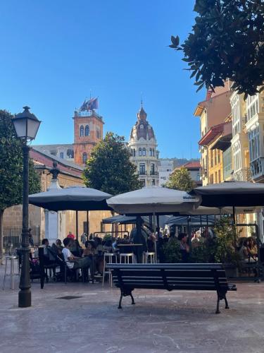 a park bench with umbrellas and people sitting at tables at San francisco in Oviedo