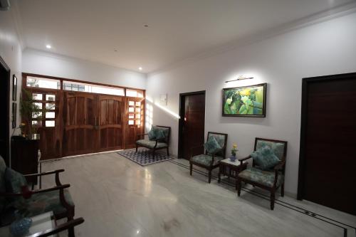 a living room with chairs and a tv on the wall at Jai Villa - A Boutique Hotel in Jaipur