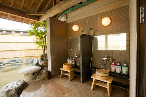 a bathroom with a shower and a tub with stools at Hotel Fuji Tatsugaoka in Fujiyoshida