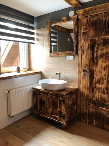 ein Badezimmer mit einem weißen Waschbecken und einem Spiegel in der Unterkunft Vojnův Městec Dům s vůní dřeva in Saar