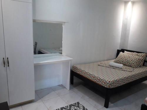 a small bedroom with a bed and a sink at JOCANAI RESIDENCES Furnished Private Room in Lusong