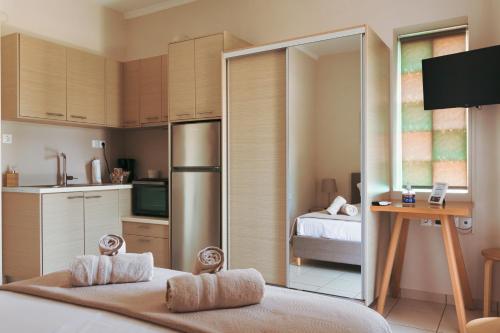 a small kitchen with a refrigerator and a bedroom at Plakoures Home in Kounoupidhianá