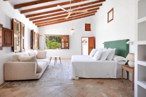 a living room with two white beds and a couch at El Convento de Biniamar in El Port de la Selva