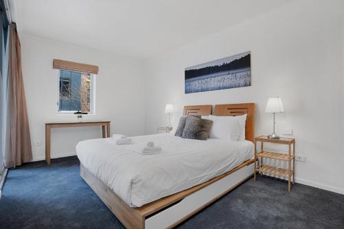 - une chambre avec un grand lit et des draps blancs dans l'établissement Contemporary Apartment, à Sydney