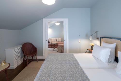 a bedroom with a bed and a living room at Valverde Santar Hotel & SPA - Relais & Châteaux in Santar