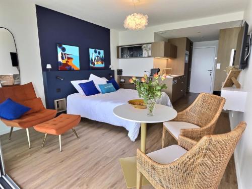 a bedroom with a bed and a table and chairs at Le Souffle Marin CONCARNEAU - VUE MER panoramique DIRECT sur la PLAGE des Sables Blancs FIBRE Parking PRIVÉ Secure PANORAMIC SEE VIEW direct ON BEACH in Concarneau