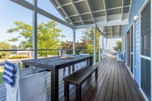 a patio with a table and chairs on a deck at Nikabel Beach House I Private Properties in Dunsborough