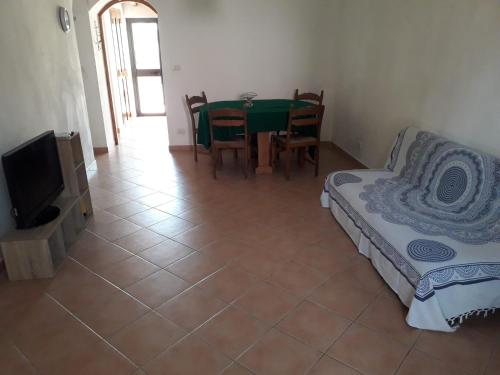 Zimmer mit einem Tisch, einem Bett und einem TV in der Unterkunft Casa Annamaria in Milazzo