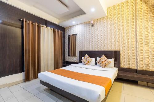FabHotel Shree Regency في بوبال: غرفة نوم بسرير كبير في غرفة