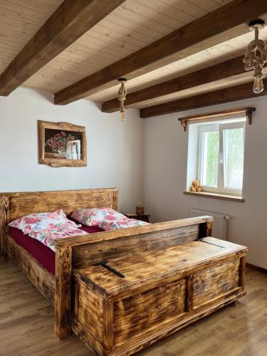 een slaapkamer met een groot houten bed en een raam bij Vojnův Městec Dům s vůní dřeva in Žďár nad Sázavou