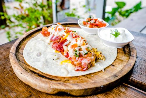 zwei Scheiben Pizza auf einer Holzplatte mit Salsa in der Unterkunft K-Bunk AoNang Center in Ao Nang Beach