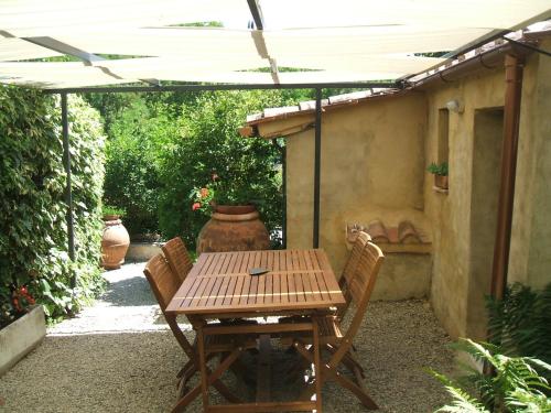 a wooden table and chairs under an umbrella at Antica Dimora in Monteroni dʼArbia