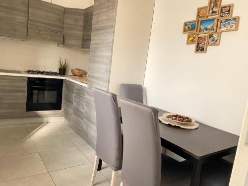 uma mesa de jantar e cadeiras numa cozinha em Terrazze Alelà apartment em Bari