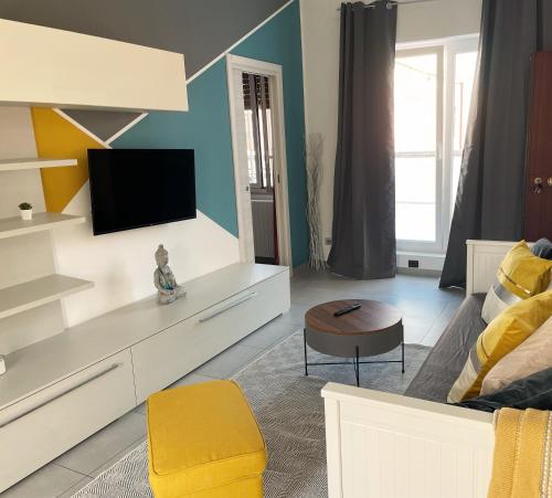uma sala de estar com uma televisão e um sofá em Terrazze Alelà apartment em Bari