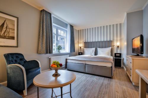 ヴェスターラントにあるSylthotel Raffelhüschen Garniのベッドとテーブルが備わるホテルルームです。