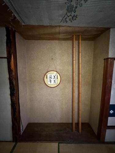 a clock on the wall in a room with bamboo at 素泊まり民宿とみや全部屋個室 in Oshima