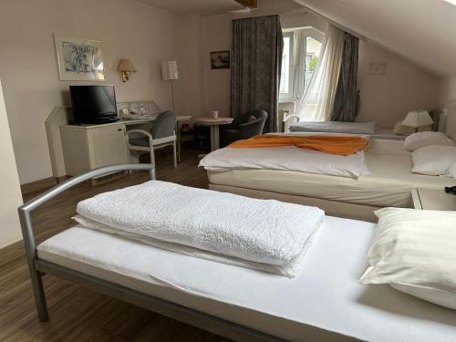 a hotel room with two beds and a desk at Hotel Garni Classico in Aschaffenburg