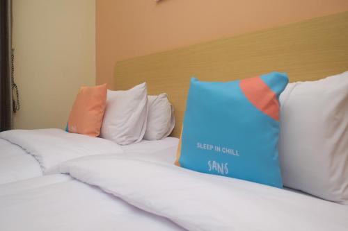 a group of pillows sitting on top of a bed at Sans Hotel City Park Medoho Semarang in Alastuwo