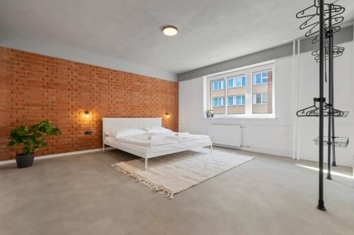 a bedroom with a bed and a brick wall at Sofia Apartment - With parking in Bratislava