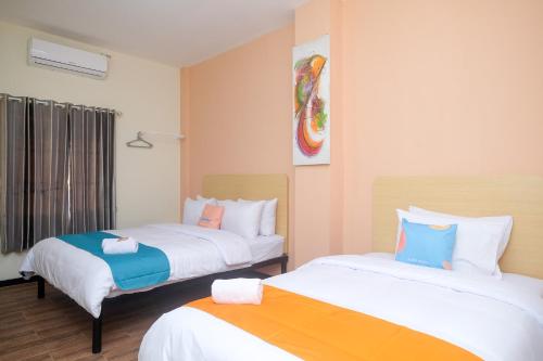 2 Betten in einem Hotelzimmer mit in der Unterkunft Sans Hotel City Park Medoho Semarang in Alastuwo