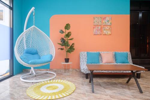 a room with a swing chair and a couch at Sans Hotel City Park Medoho Semarang in Alastuwo