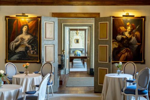 a dining room with tables and paintings on the walls at Valverde Santar Hotel & SPA - Relais & Châteaux in Santar