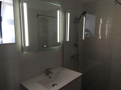 a bathroom with a sink and a mirror and a shower at Casa Madeira in Silves