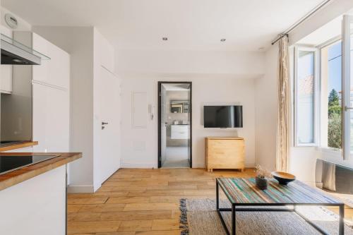Il comprend un salon avec une table et une cuisine. dans l'établissement T2 Les Altéas - Cozy & Modern apartment - quiet area - city center, à Biarritz