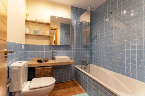 uma casa de banho em azulejos azuis com um WC e uma banheira em Dream sea view Villa with private swimmingpool and Jacuzzi em Golf del Sur
