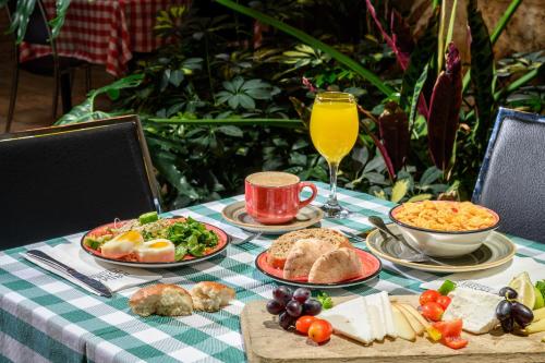 une table avec des plaques alimentaires et un verre de jus d'orange dans l'établissement Prima Park Hotel Jerusalem, à Jérusalem