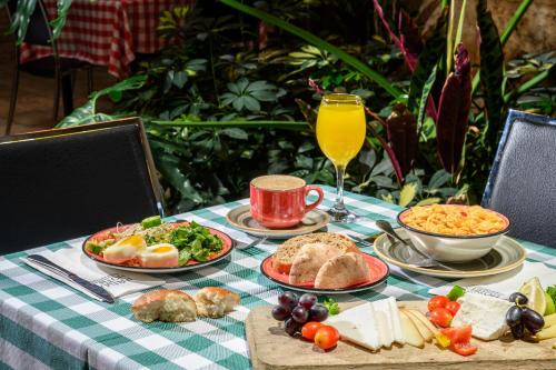 einen Tisch mit Teller mit Lebensmitteln und ein Glas Orangensaft in der Unterkunft Prima Park Hotel Jerusalem in Jerusalem