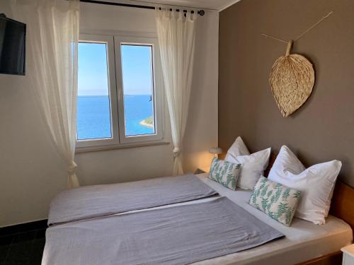 - une chambre avec un lit et une grande fenêtre dans l'établissement Apartments Jasmina, à Vinišće