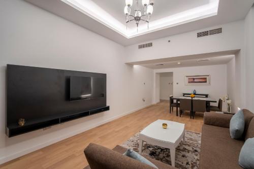 a living room with a large flat screen tv at Rose Garden Hotel Apartments - Al Barsha, Near Metro Station in Dubai