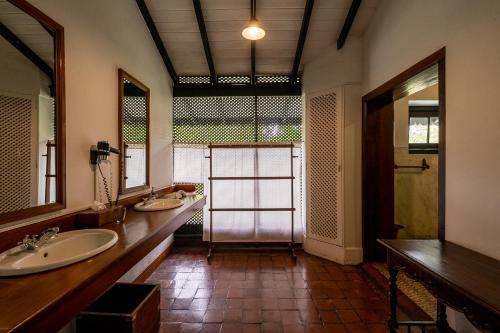 een grote badkamer met 2 wastafels en een spiegel bij Horathapola Estate in Marawila