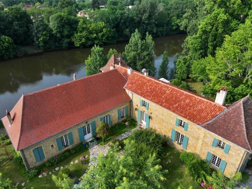 an aerial view of an old house on a river at La Rebière d'Or, B&B et Gîte in Mouleydier