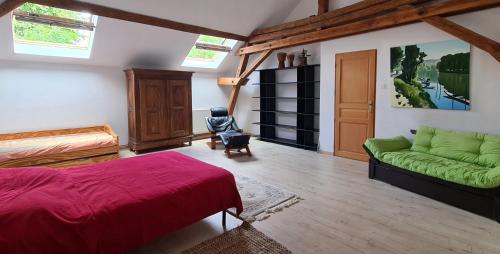 a bedroom with a bed and a green couch at Grange Des Arts in Saint-Nabor