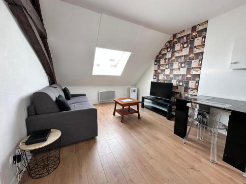 un salon avec un canapé et une table dans l'établissement Appartement au centre ville de Sens, à Sens
