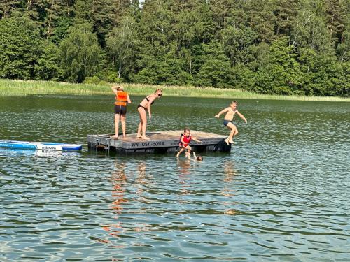 a group of people standing on a dock in the water at Drift Away in Mielno