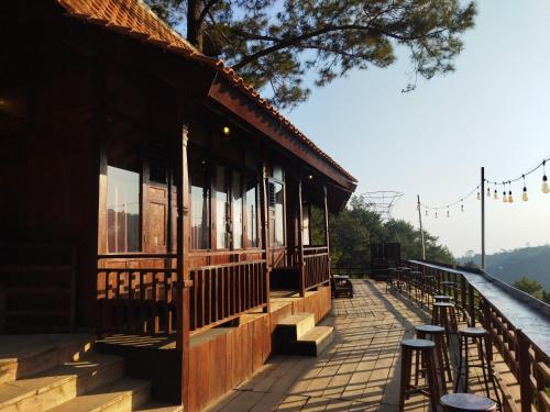 a building with tables and stools on a patio at Pijar Resort Powered by Cocotel in Kudus