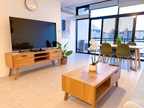 a living room with a large television and a table at Convenient 2BR in Marrickville in Sydney