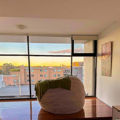 a living room with a large window with a chair at Convenient 2BR in Marrickville in Sydney
