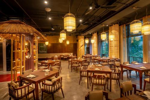 a restaurant with wooden tables and chairs and lights at My Way Hotel & Residence Ha Noi in Hanoi